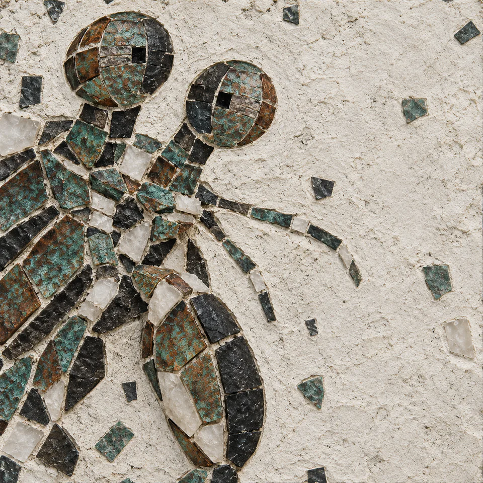 A mosaic-style mantis shrimp head with two uneven eye stalks and one closed oval club fills the left of a pale grout field.